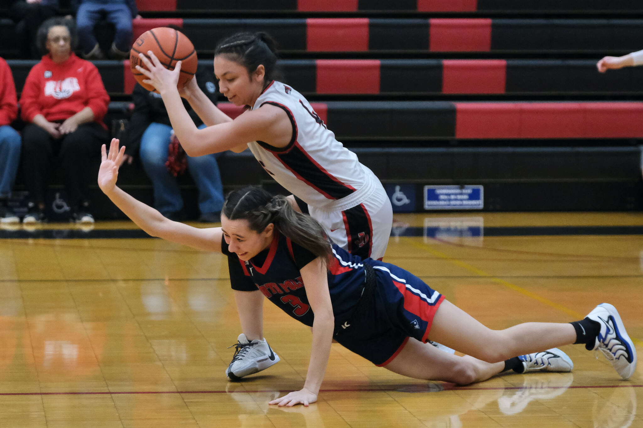 Juneau-Douglas High School: Yadaa.at Kalé senior Mary Johnson (4) pulls a ball away from North Pole sophomore Miyah Guzman (3) during Senior Night honors Saturday at George Houston Gymnasium. (Klas Stolpe / Juneau Empire)