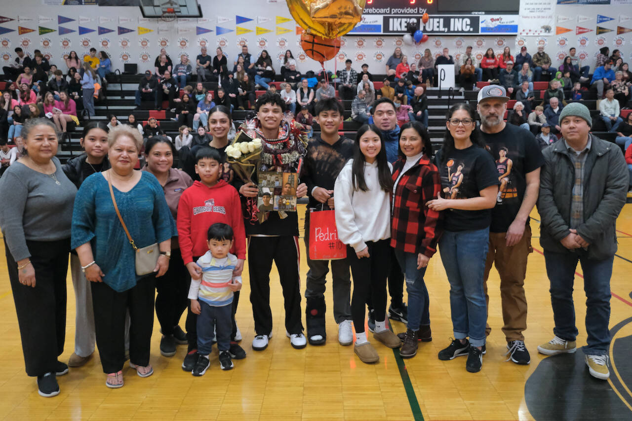 Friends and family of Juneau-Douglas High School: Yadaa.at Kalé Crimson Bears senior Pedrin Saceda-Hurt during Senior Night honors Saturday at the George Houston Gymnasium. (Klas Stolpe / Juneau Empire)