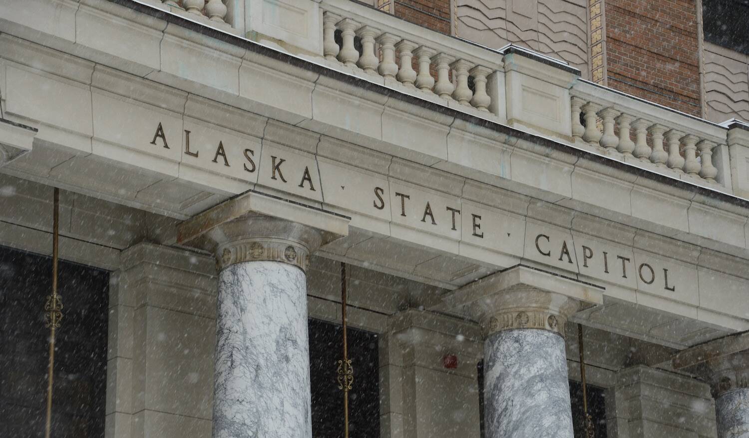 Snow falls on the Alaska State Capitol on Monday, Jan. 30, 2023. (James Brooks/Alaska Beacon)