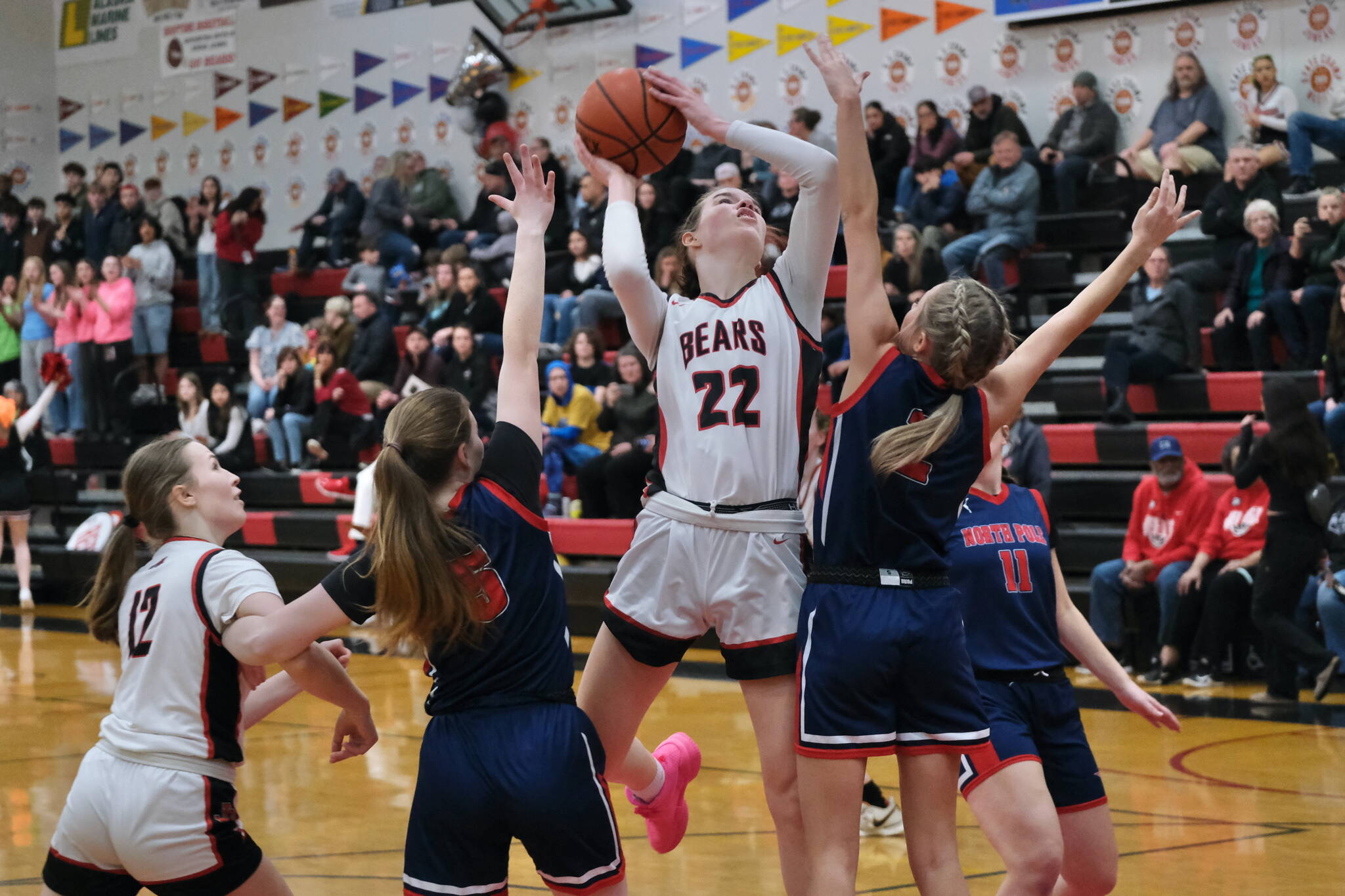 Juneau-Douglas High School: Yadaa.at Kalé senior Kerra Baxter (22) scores against North Pole last weekend as sophomore Bergen Erickson (12) looks on. The Crimson Bears open the 2A/4A Region V tournament against Kayhi at 6 p.m. Thursday in Ketchikan's Clarke Cochran Gymnasium. (Klas Stolpe / Juneau Empire)