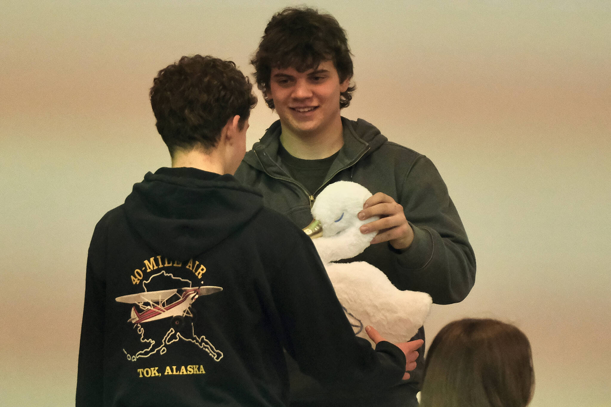 Juneau-Douglas High School: Yadaa.at Kalé hockey senior Luke Bovitz presents a senior gift to a hockey underclassman during the Crimson Bears hockey banquet Sunday in the JDHS commons. (Klas Stolpe / Juneau Empire)