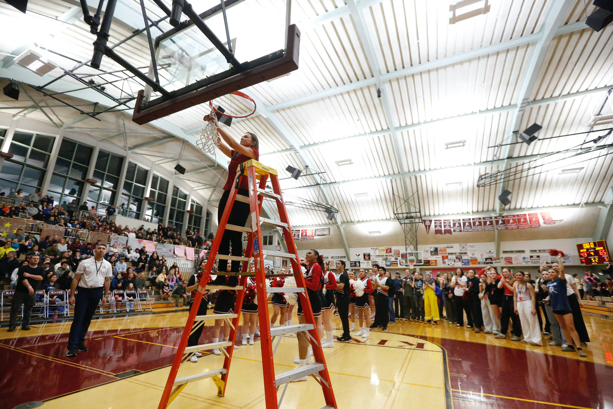 Juneau-Douglas High School: Yadaa.at Kalé coach Tanya Nizich cuts down the net after their 65-43 victory over Kayhi, winning the Region V 4A Basketball Tournament at the Clarke Cochrane Gymnasium on Friday. Juneau-Douglas eliminated Kayhi and will advance to play at state. (Christopher Mullen / Ketchikan Daily News)