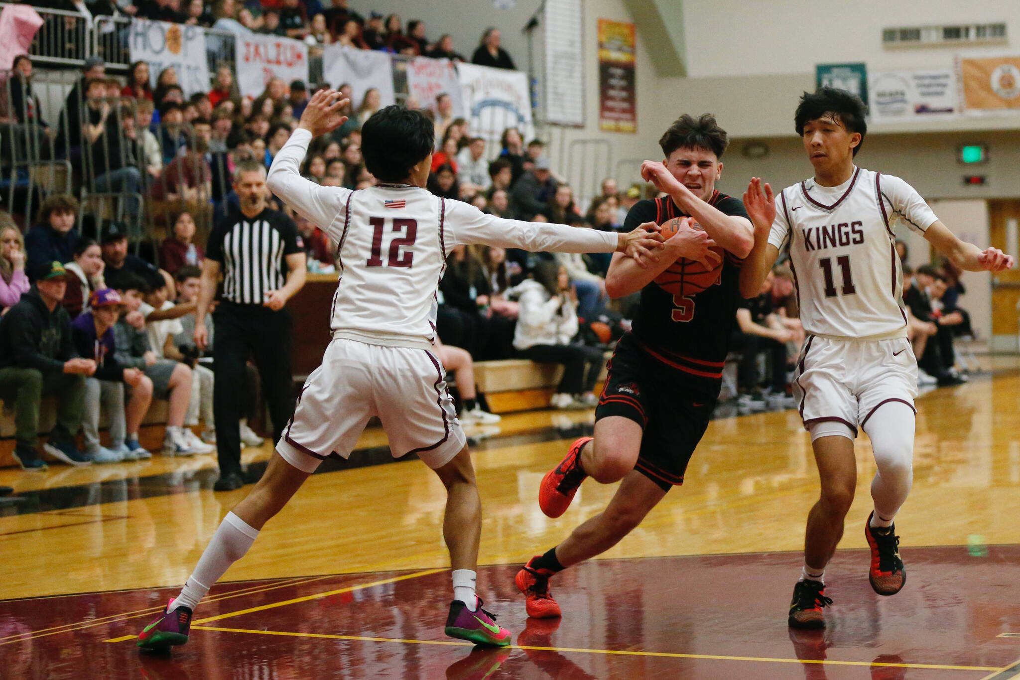 Juneau-Douglas High School: Yadaa.at Kalé’s Brandon Casperson runs past defenders during Ketchikan’s 74-54 victory over Juneau-Douglas, winning the Region V 4A Basketball Tournament at the Clarke Cochrane Gymnasium on Friday. Ketchikan eliminated Juneau-Douglas and will advance to play at state. (Christopher Mullen / Ketchikan Daily News)