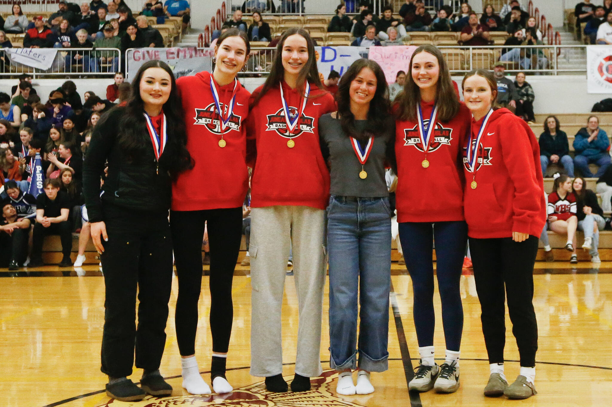 The 4A Girls All Conference players Juneau-Douglas’ Layla Tokuoka, Kerra Baxter, Caiylnn Baxter, Kayhi’s Aspen Bauer, Juneau-Douglas’ Gwen Nizich and Cambry Lockhart stand for a photo at the Clarke Cochrane Gymnasium on Saturday. (Christopher Mullen / Ketchikan Daily News)